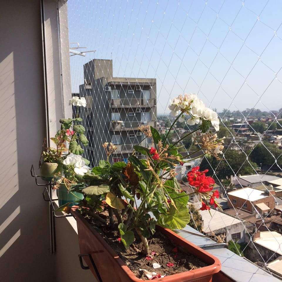 Balcón decorado con plantas protegido con red de seguridad transparente - No afecta la estética