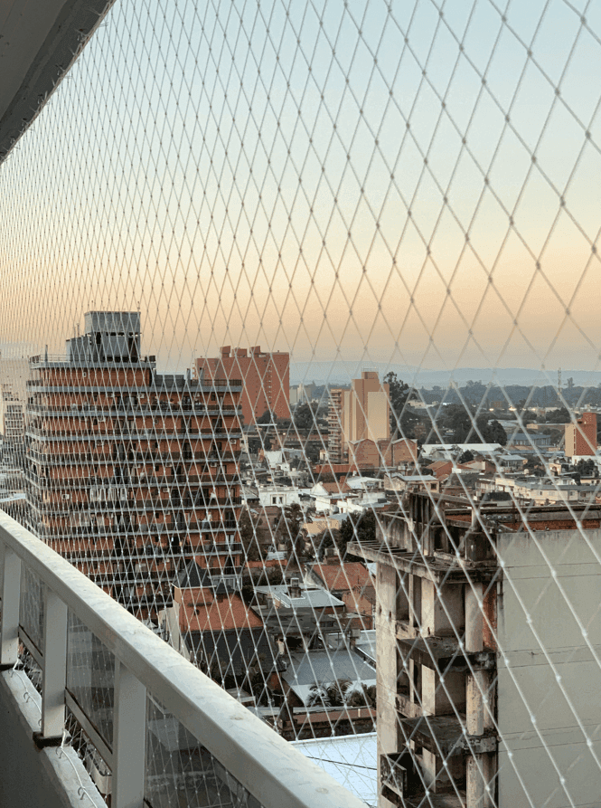 Red de seguridad instalada en balcón urbano al atardecer - Grupo Redes Tucumán y CABA